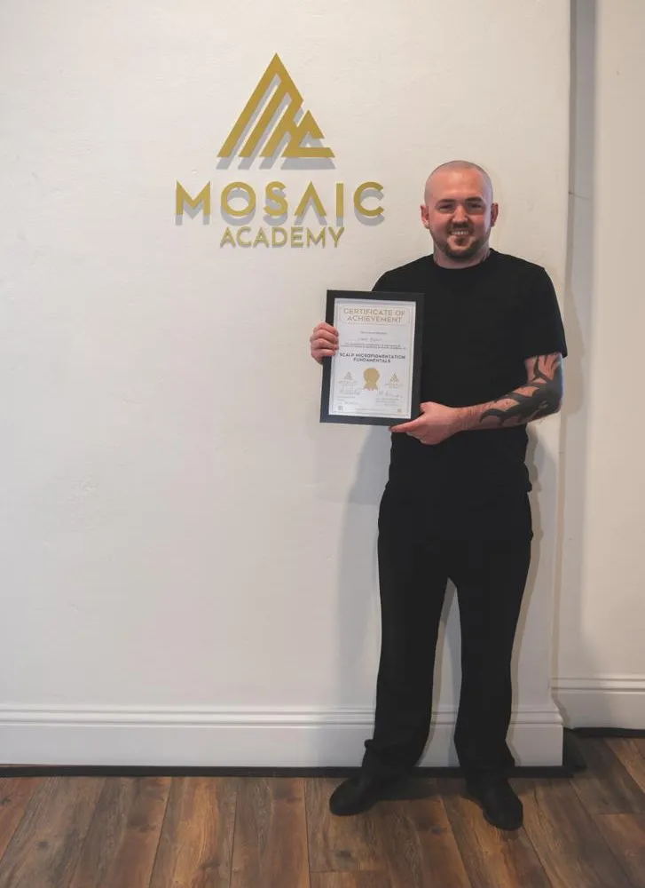 Technician holding an SMP certificate of achievement from Mosaic Academy
